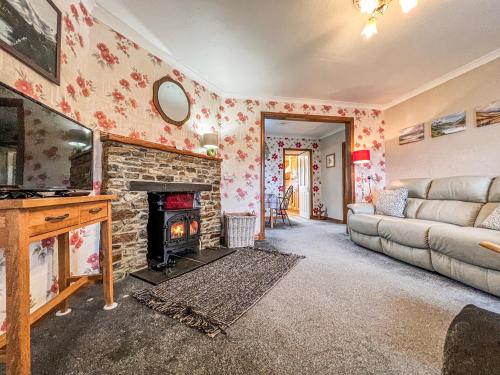 a living room with a couch and a fireplace at Laxdale Cottage in Leverburgh