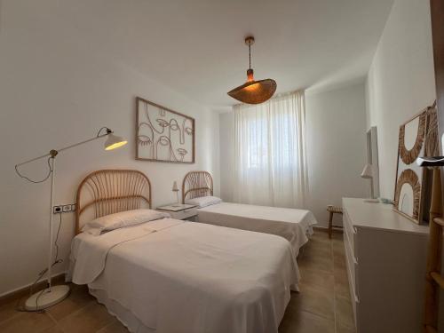 a bedroom with two beds and a lamp at Villa Chloe in Punta Grossa