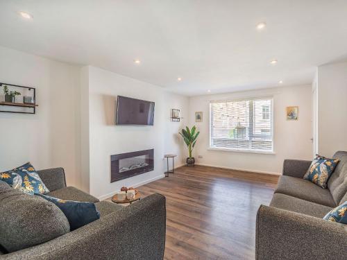 a living room with two couches and a tv at Hotspur View in Alnwick