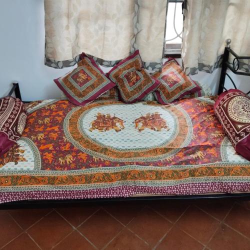 a bed with a comforter with a plate on it at Natural bliss in Tiruchirappalli