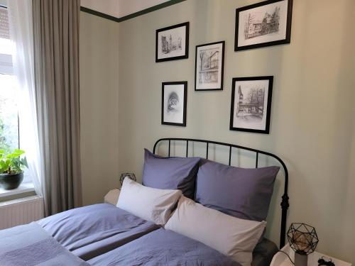 a bed in a bedroom with framed pictures on the wall at Neu! Fewo Fiedler I in Finsterwalde
