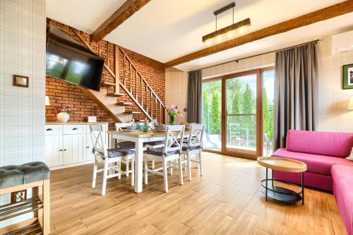 a living room with a pink couch and a table at Domki Mazurska Dolina in Mikołajki
