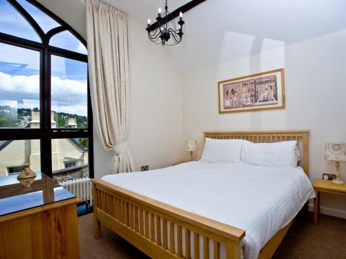 a bedroom with a bed and a large window at 3 Torwood Gables in Torquay