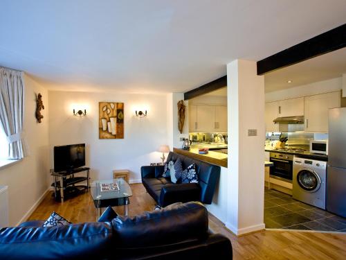 a living room with a couch and a kitchen at 3 Torwood Gables in Torquay