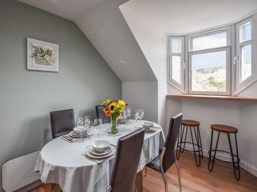 a dining room with a table and chairs and a window at Tay Views Apartment in Perth
