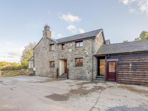 an old stone house with a garage at Rhiew Banc in Aberhafesp