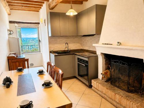 a kitchen with a fireplace and a table and a kitchen with a tableablish at Foxes house in Monte Fabbri