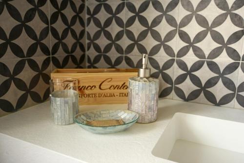 a bathroom counter with a sink and a soap dispenser and a box at Agriturismo Cascina Sciulun in Monforte dʼAlba