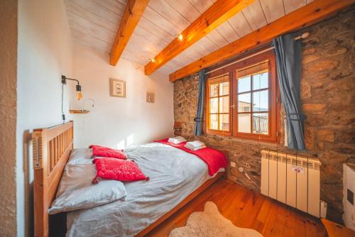 a bed in a room with a stone wall at La Grange de la Petite Ourse in Les Angles