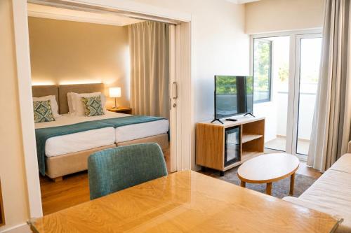 a hotel room with a bed and a television at Santa Eulalia Hotel & Spa in Albufeira