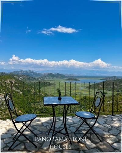 a table and chairs on a patio with a view at Panorama Stone Houses - Skadar Lake in Cetinje