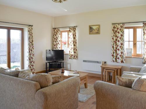 a living room with two couches and a tv at Gwel-Y-Lyn in Mydroilin