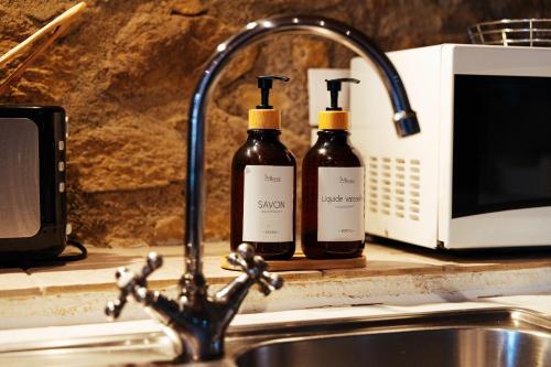two bottles of wine sitting next to a kitchen sink at La Grange de Cassiopée in Les Angles
