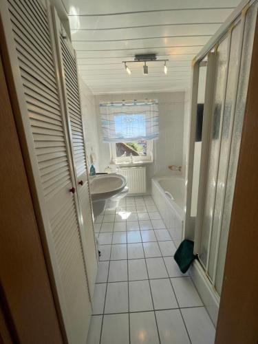 a bathroom with a tub and a sink and a bath tub at Ferienwohnung Matthias Lang in Rugendorf