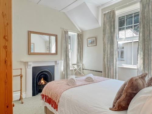 a bedroom with a bed and a fireplace at Rockford Cottage Brendon in Countisbury