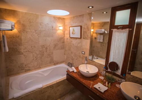a bathroom with a tub and a sink and a mirror at Aranwa Pueblito Encantado del Colca in Coporaque