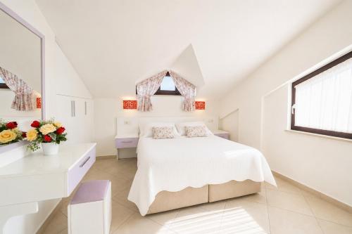a white bedroom with a bed and a window at Villa Garden Island in Dalyan