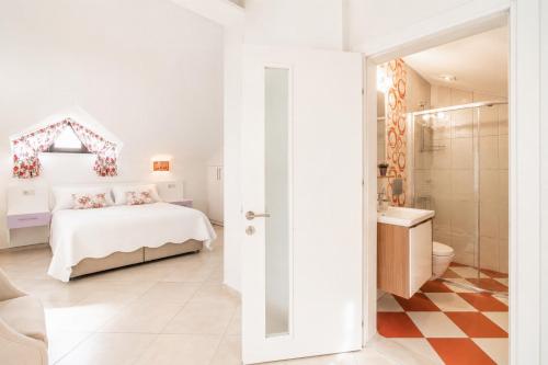 a white bedroom with a bed and a bathroom at Villa Garden Island in Dalyan