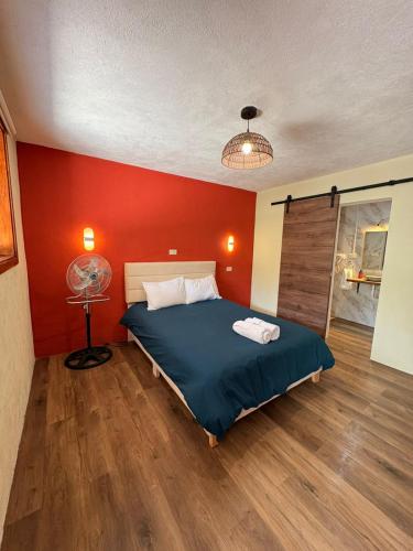 a bedroom with a bed and a red wall at Naab apart complex in Panajachel