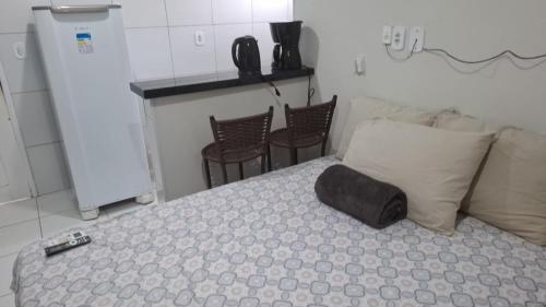 a bedroom with a bed with chairs and a counter at my sweet place 33 in São Luís