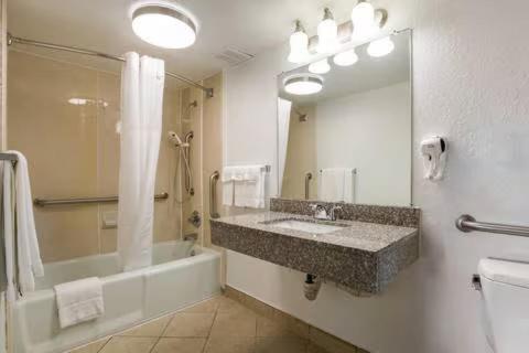 a bathroom with a sink and a tub and a mirror at The Cherrywood Inn in Georgetown