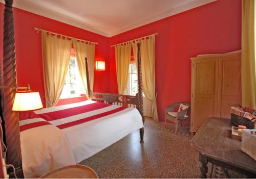 a red bedroom with a bed and a window at Villa Casa Rosa in Procchio