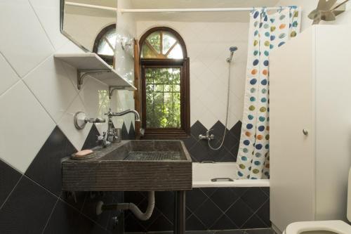 a bathroom with a sink and a window at Villa Thea in Kalogria