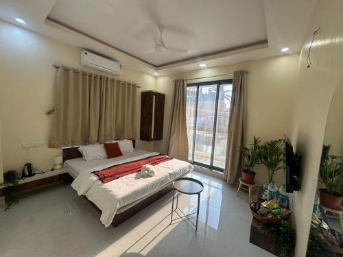 a bedroom with a bed and a large window at The Sora Stay in Alibaug