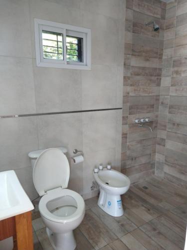 a bathroom with a toilet and a sink and a window at Quinta El Encuentro Junín in Junín