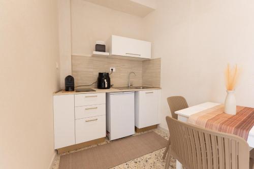 a kitchen with white cabinets and a table and a counter at Civico Dodici in Modica