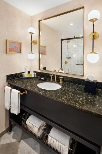 a bathroom with a sink and a large mirror at Hilton Pearl River in Pearl River