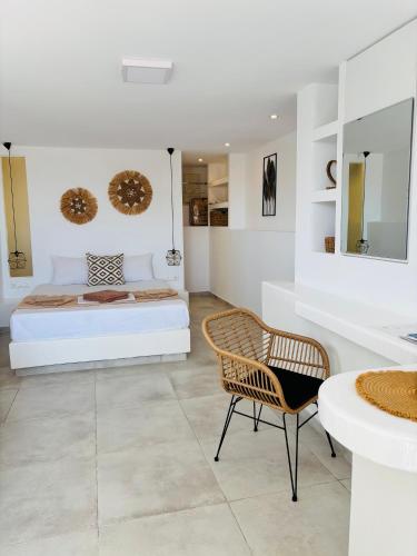 a white bedroom with a bed and a chair at Irini's House Sunbeam in Dhragoulás