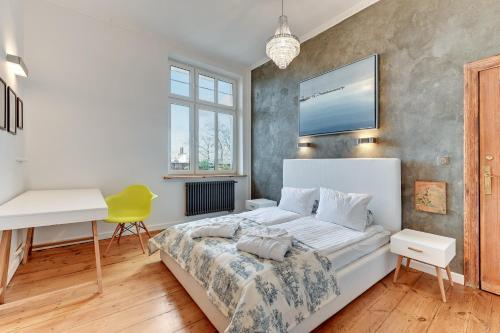 1 dormitorio con cama blanca y escritorio en Lion Apartments - Family Stay, en Sopot