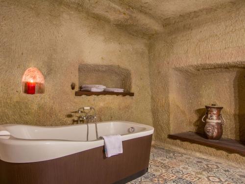 a bathroom with a bath tub in a room at Minia Cave Hotel in Ortahisar