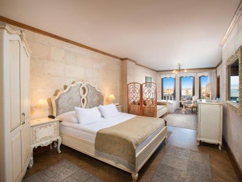 a bedroom with a large bed and a bathroom at Minia Cave Hotel in Ortahisar