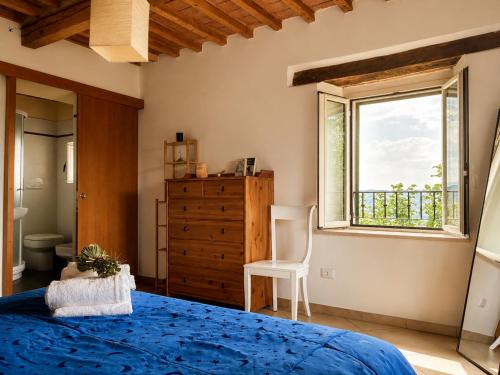 a bedroom with a blue bed and a window at Foxes house in Monte Fabbri