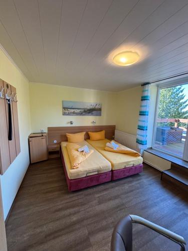 a bedroom with a bed in a room with a window at Hotel Gesellschaftshaus in Bergen auf Rügen