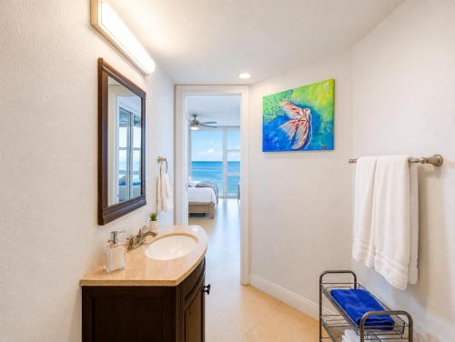 a bathroom with a sink and a mirror at Beachfront Condo with Pool, Balcony & Ocean Views in Fort Lauderdale