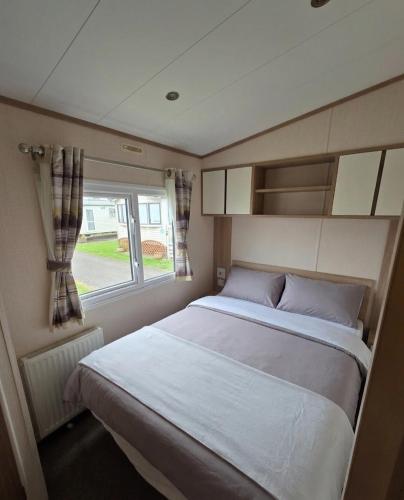 a bedroom with a bed and a window at The Cavern Retreat in Rhyl