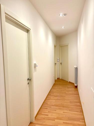 an empty hallway with a door and wooden floors at G&G Suites in Bugia