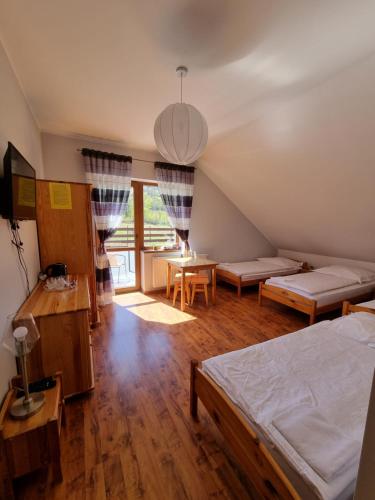a bedroom with a bed and a living room at Noclegi u Belli in Jugowice
