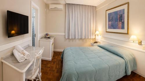 a hotel room with a bed and a television at Hotel Bruggemann in Florianópolis