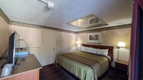 a hotel room with a bed and a flat screen tv at Red Lion Motel Southampton in Southampton