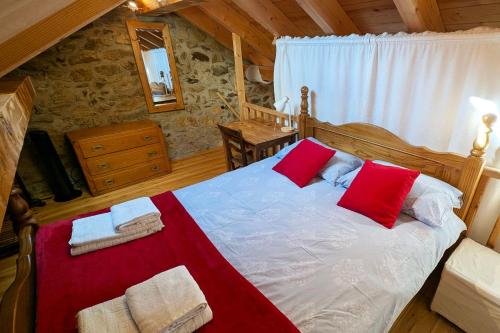 a bedroom with a bed with red and white pillows at La Ferme Des Astres in Les Angles