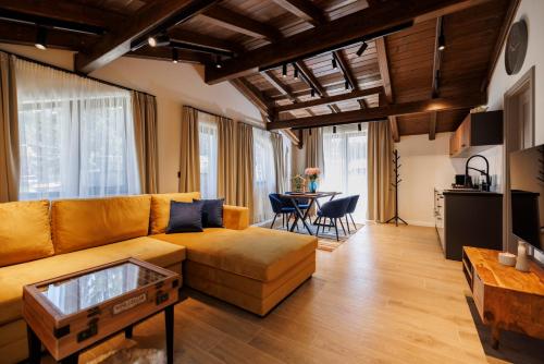 a living room with a couch and a table at Къща за гости Domus Harmonia - Jacuzzi & BBQ near Bansko in Banya