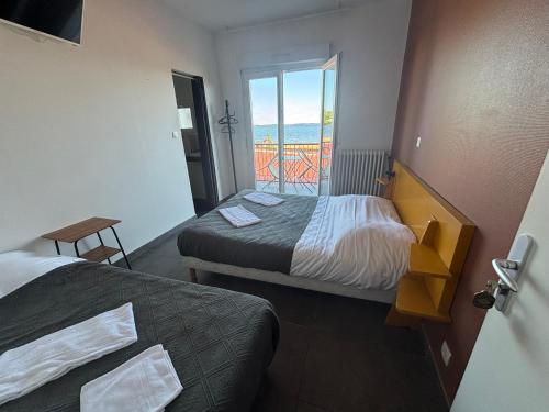 a hotel room with two beds and a balcony at Le Moutchico in Lacanau