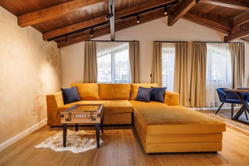 a living room with a couch and a table at Къща за гости Domus Harmonia - Jacuzzi & BBQ near Bansko in Banya