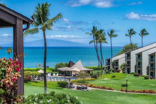 a view of a resort with palm trees and the ocean at 257 Hale Kamaole in Wailea