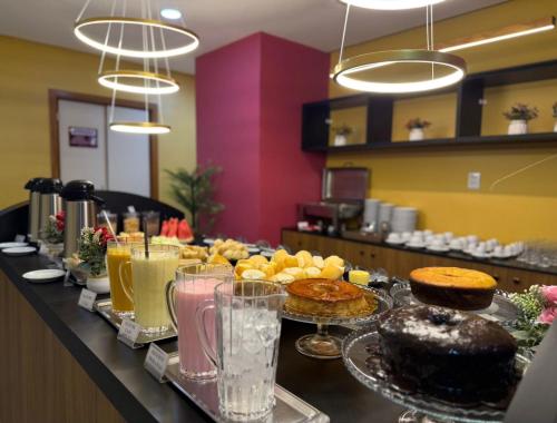 a buffet with cakes and pastries on a table at Domus Hotel Rio Verde - Parauapebas in Parauapebas