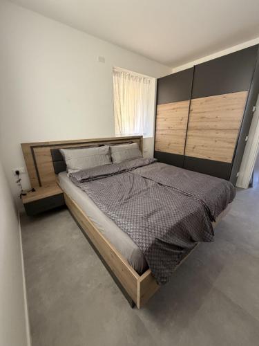 a bedroom with a large bed with a wooden headboard at Z&N Apartment in Levico Terme